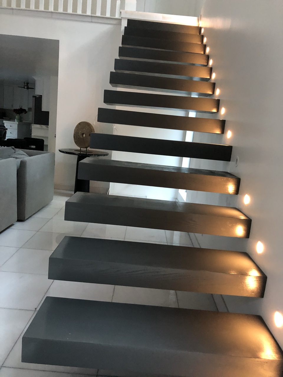 Modern floating staircase with dark wood treads and wall step lights